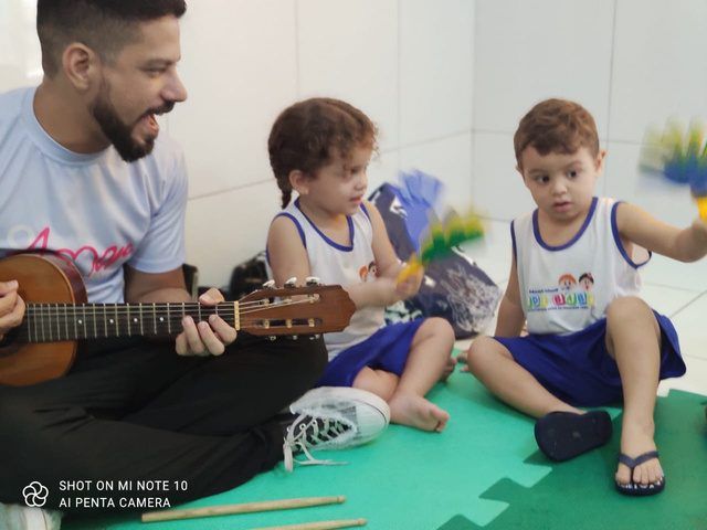 Professor tocando violão para as crianças
