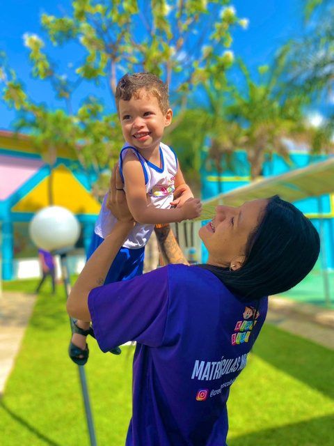 Criança brincando no parque com a professora