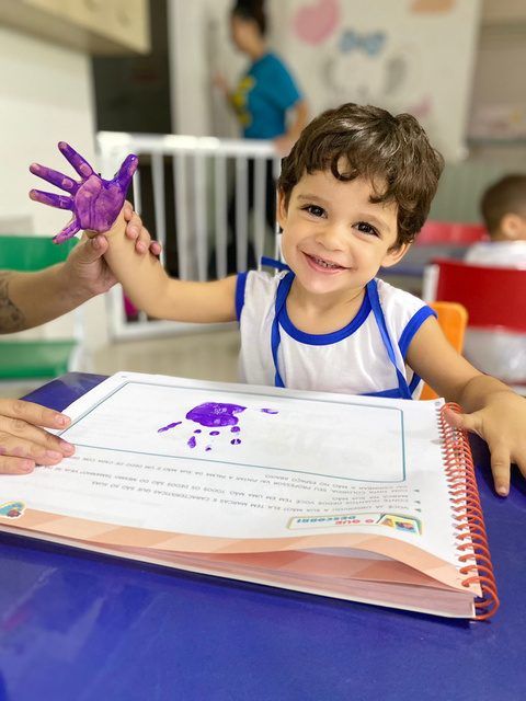 Aluno pintando com a mão