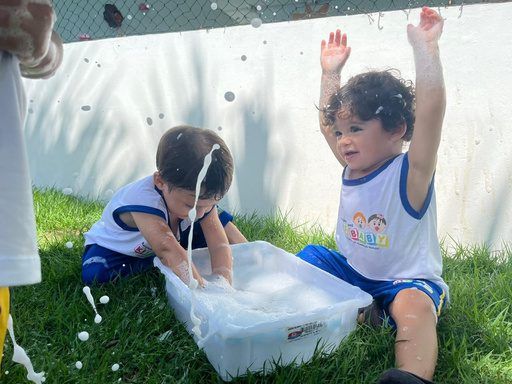 Crianças brincando com água no gramado