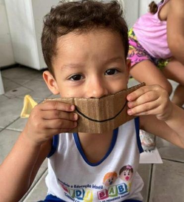Aluno do Infantil III com uma máscara de papelão